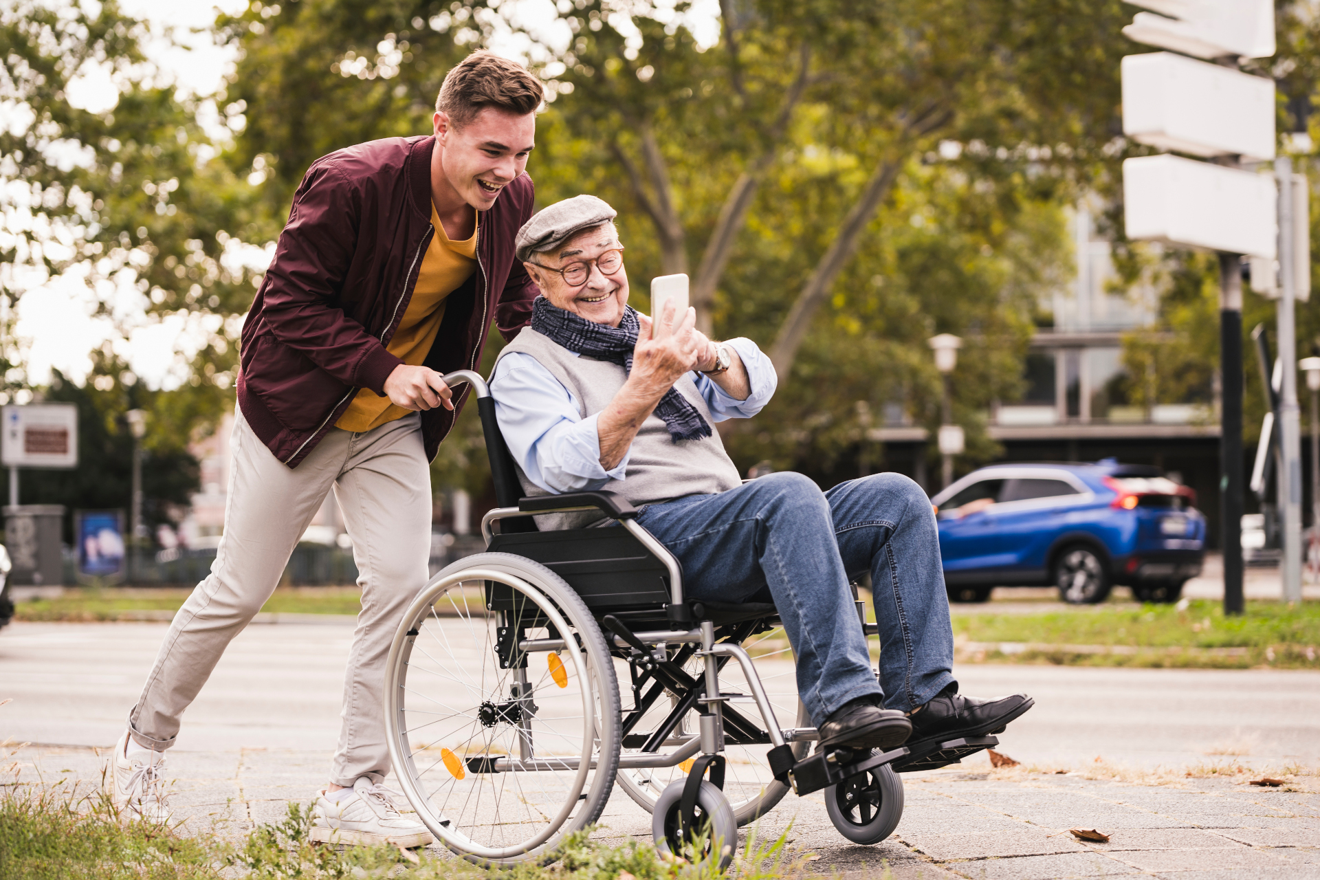 Mężczyzna popycha starszą osobę na wózku inwalidzkim